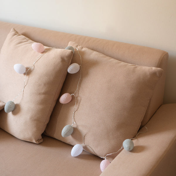 Couch adorned with pillows and 10 LED Cotton Egg Lights