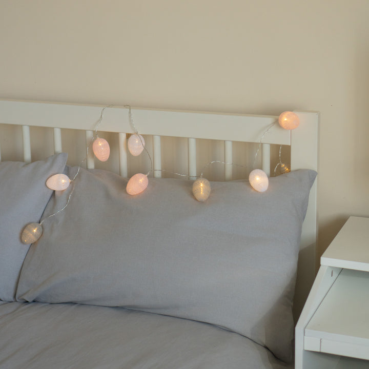10 LED Cotton Egg Lights displayed on a white bed