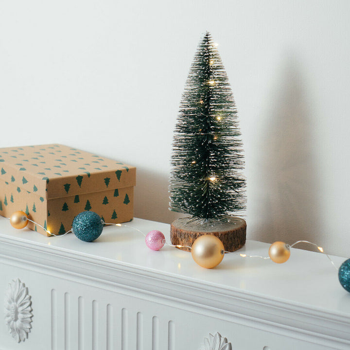 15 LED Bauble Fairy String Light on a small Christmas tree next to a gift box
