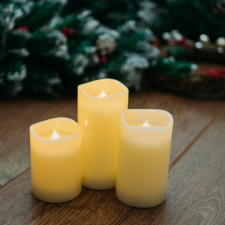 Three LED drip effect candles from the set positioned on a wooden table
