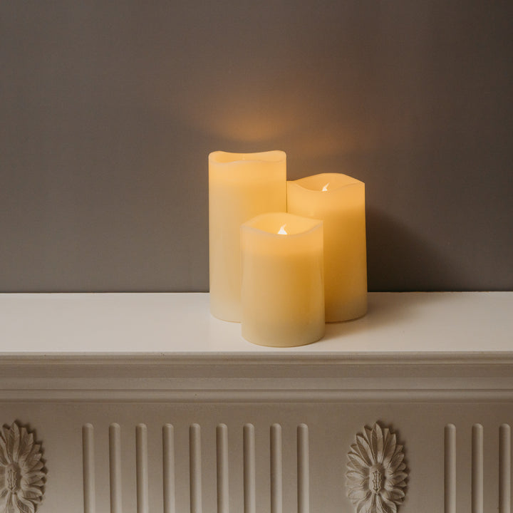 Three-piece LED drip effect candle set showcased on a shelf with a fireplace backdrop