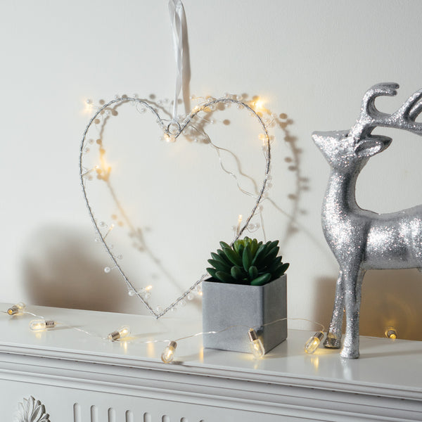 Heart Wreath Fairy Light in a heart shape next to a deer on a mantle