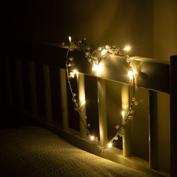 Heart Wreath Fairy Light in a heart shape on a bed